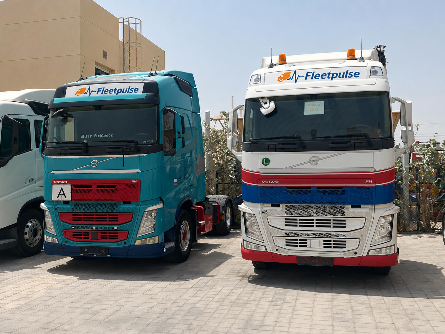 Two FleetPulse-branded Volvo FH tractor units parked at the yard